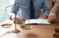 Notaries working at table in office, focus on scales of justice Royalty Free Stock Photo