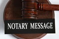 NOTARY MESSAGE - words on a black sheet against the background of a judge\'s gavel