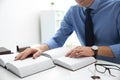 Notary studying law books at table in office