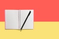 Note book and color pen on yellow and red background Royalty Free Stock Photo