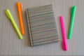 Note book and four colored Markers. Royalty Free Stock Photo