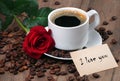 Note i love you. coffee in a white cup. cup of coffee, roasted coffee beans and red rose on a wooden table. romantic coffee Royalty Free Stock Photo