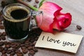 Note i love you. cup of coffee, roasted coffee beans and red rose on a wooden table. romantic coffee. selective focus Royalty Free Stock Photo