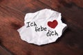 Note `Ich liebe dich` on torn slip of paper