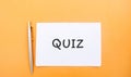 A note with the inscription Quiz and a pen. Business or education concept. Answers to oral or written questions from various