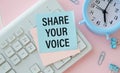 note with the message of share your voice, with desk background Royalty Free Stock Photo