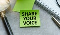 note with the message of share your voice, with desk background Royalty Free Stock Photo