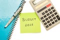 Note pad, a pen, a calculator and a yellow paper with 2025 budget phrase written on it on a white background Royalty Free Stock Photo