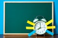 Note paper sticky and vintage alarm clock and blank green chalkboard on table with copy space for add text notice something, list Royalty Free Stock Photo