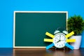 Note paper sticky and vintage alarm clock and blank green chalkboard on table with copy space for add text notice something, list