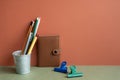 Note, pencil holder, clip on khaki desk. red wall background. workspace, office supply Royalty Free Stock Photo