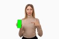 Note that. Pretty young blond woman is pointing finger at mobile phone blank screen in her hand Royalty Free Stock Photo