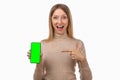 Note that. Pretty young blond woman is pointing finger at mobile phone blank screen in her hand Royalty Free Stock Photo