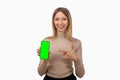 Note that. Pretty young blond woman is pointing finger at mobile phone blank screen in her hand Royalty Free Stock Photo