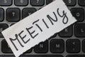 A note reading MEETING placed on a black computer keyboard, symbolizing organization and productivity in the workplace. Royalty Free Stock Photo