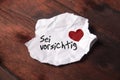 Note `Sei vorsichtig` on torn slip of paper