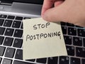 A note showing the phrase Stop Postponing