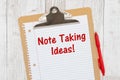 Note Taking Ideas message on lined paper with a pen on a clipboard Royalty Free Stock Photo