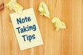 Note Taking Tips message on a notepad with crumpled paper on wood desk Royalty Free Stock Photo