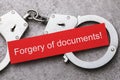 Note with text and handcuffs, top view. The concept of punishment for falsification of documents