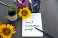 Note to self. Message on a notebook - Learn to always value yourself. Self love and care concept. With sunflowers and coffee cup.