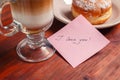 A note with the words `I love you` and a Cup of cappuccino