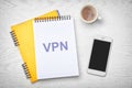 Notebook with acronym VPN on white wooden table, flat lay. Secure network connection