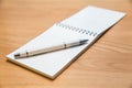 A notebook and ballpoint pen lying on a wooden table