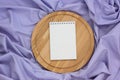 Notebook with blank cover and circular cutting Board on a purple striped tablecloth Royalty Free Stock Photo