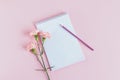 Notebook with blank page, pencil and Carnation flower on a pink pastel background Royalty Free Stock Photo