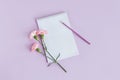 Notebook with blank page, pencil and Carnation flower on a violet pastel background Royalty Free Stock Photo