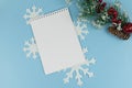 Notebook on blue background with christmas decor. Frame with decorative elements and copyspace on white backdrop. New year goals Royalty Free Stock Photo