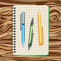 Notebook, blue pen, green pen and yellow pen