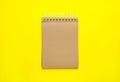 Notebook with brown paper pages on yellow background, top view Royalty Free Stock Photo