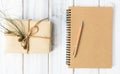 Notebook,brown pencil and pacel gift box on white wood table bac Royalty Free Stock Photo