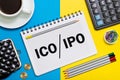 A Notebook with Business notes initial coin offering ICO vs IPO Initial Public Offering with office tools