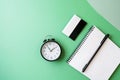 Notebook, clock, and card arranged on green background with open space symbolizing flexi topaz and copy space for design use Royalty Free Stock Photo