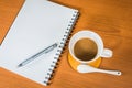 Notebook and coffee on wooden background