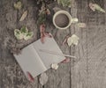 Notebook and coffee on wooden table decorated with dried leaves Royalty Free Stock Photo