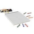 Notebook with colored chalks and pencils with a sharpener Royalty Free Stock Photo