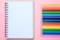 Notebook and colored pencils on pink background Royalty Free Stock Photo