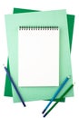 Notebook and colored pencils on sheets of textured paper Royalty Free Stock Photo