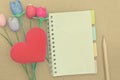 Notebook with colorful artificial tulips heart shape a