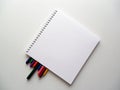 Notebook and coloured crayons in white