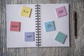 Notebook covered in post it notes, taken on a wooden background Royalty Free Stock Photo
