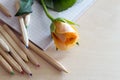 Notebook, crayons and rose flower on wooden background, Teacher Day concept Royalty Free Stock Photo