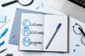 Notebook with CRM abbreviation on white office table, flat lay. Customer Relationship Management Royalty Free Stock Photo