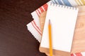 Notebook for culinary recipes on a cutting board with napkin.