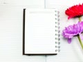 Notebook diary and beautiful artificial gerbera flower bouquet background Royalty Free Stock Photo