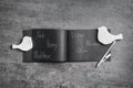 Notebook with different baby names, pen and bird shaped figures on grey table, flat lay Royalty Free Stock Photo